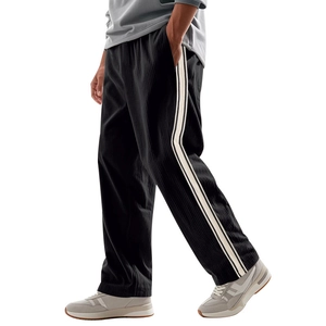 Detail view of black corduroy casual pants with ivory side stripes and textured fabric