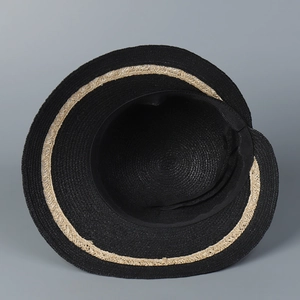 Close-up of the black woven raffia straw hat showing fine texture and beige trim detail