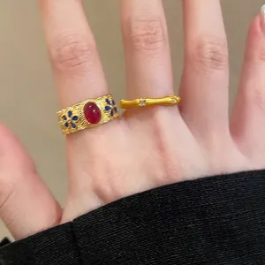 Detail of vintage gold bamboo ring with red ruby inlay and blue enamel floral accents