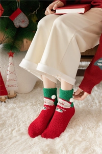 Detailed view of plush Christmas socks with Santa Claus pattern and cozy holiday decor