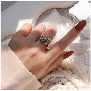 Detailed view of silver titanium steel ring with double ball design on model hand