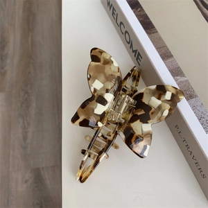 Detail shot of acetate butterfly hair claw clip with tortoise shell pattern and metal spring