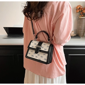 Dettaglio di una borsa chic in bianco e nero con stampe di fiocchi e fibbia elegante