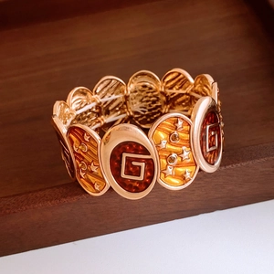 Detail of vintage gold bracelet with amber enamel and geometric star patterns