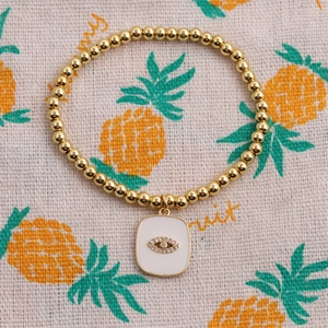 Golden beaded stretch bracelet with white enamel evil eye charm and sparkling zircon