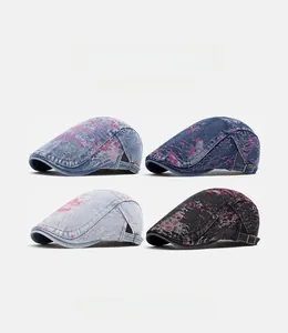 Dettaglio di quattro berretti in denim lavato con schizzi rosa e fibbie metalliche