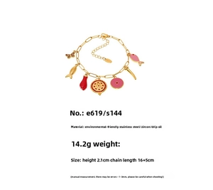 Detail of gold stainless steel charm bracelet with colorful enamel fish and zircon pendants