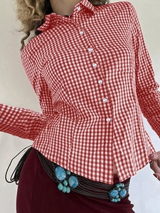 Detail shot of the red and white checkered pattern on a long-sleeved button-up shirt