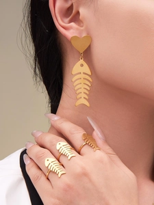 Close-up of model wearing gold herringbone heart earrings and adjustable open rings