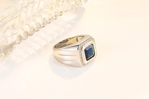 Macro shot of silver men's ring with square blue sapphire and micro-pave zircon details