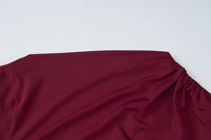 Close-up of wine red summer dress shoulder seams with high-quality knit fabric texture