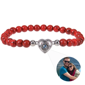 Detail showing red stone beads and silver heart pendant with photo projection feature