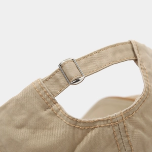Detail of adjustable metal buckle and stitching on khaki cotton newsboy cap band