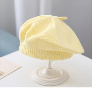 Detail of yellow knit baby beret showing soft texture and ribbed brim design