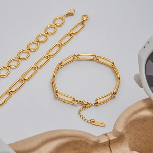 Flat lay of 18K gold plated paperclip bracelets with crystal accents and chain links