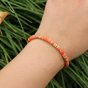 Close-up of woven imperial stone bead bracelet with gold spacer beads on a wrist