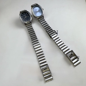 Close-up of NAIDU oval silver alloy watches with deep and light blue dials on paper