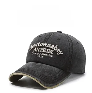 Detailed close-up of vintage embroidered lettering on washed dark grey baseball cap