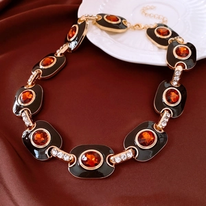 Vue détaillée du collier doré vintage avec pierre d'ambre et incrustation d'émail noir