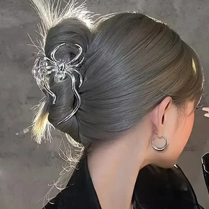 Silver spider-shaped metal hair claw clip worn on grey hair for Halloween style