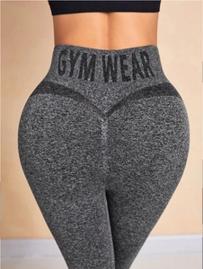 Détail du legging de yoga taille haute avec lettrage GYM WEAR et coutures galbantes