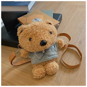 Close-up of brown plush teddy bear crossbody bag wearing a grey hoodie on wooden floor
