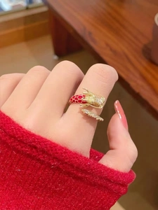 Detalle macro de anillo de dragón chapado en oro 18K con esmalte rojo y circonitas