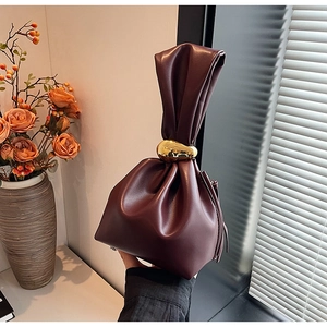 Close-up of wine red drawstring bucket bag with elegant oversized gold metal rings