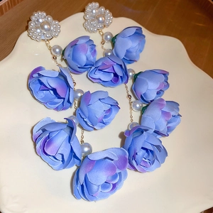 Detail of blue fabric rose petals and white pearls on long tassel drop earrings