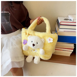 Detail of yellow plush handbag with 3D teddy bear and flower accents for kids