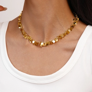 Close-up of golden heart-shaped sequins fringe necklace on model for fashion look
