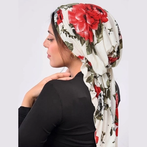 Detail of red floral print on white hijab headscarf with fabric texture on a model