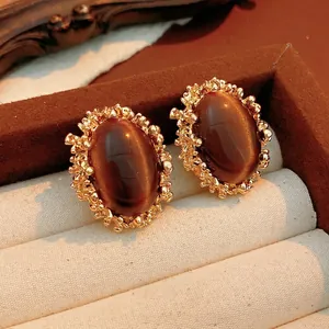 Vintage gold stud earrings with oval tiger eye stones and lava textured frames