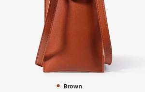Close-up of the fine stitching and side profile of this brown minimalist crossbody phone bag