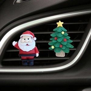 Close-up of Santa Claus and Christmas tree clips on a car air conditioning vent