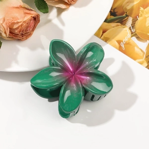 Detail of flower hair claw with green purple gradient and subtle golden glitter finish