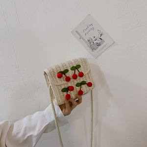 Handwoven straw crossbody bag with 3D cherry accents and thin shoulder strap