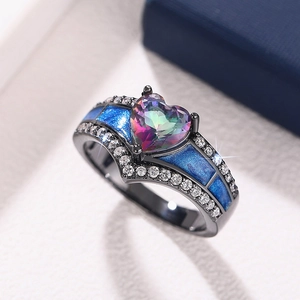 Detalle de anillo con gema multicolor en forma de corazón y metal negro con esmalte