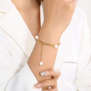 Detailed close-up of a double-layer gold titanium steel bracelet with white pearls