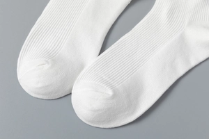 Gros plan de chaussettes blanches en coton côtelé montrant la texture du tricot fin