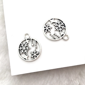 Makroaufnahme von Vintage-Silber-Schneeflocken-Anhängern für DIY-Schmuckherstellung