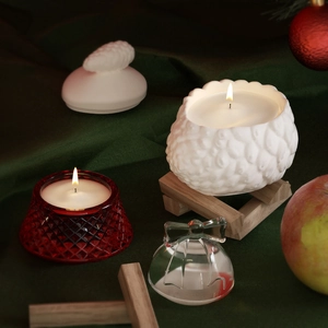 Geurkaarsenset met witte dennenappelbeker op houten standaard en rood gefacetteerd glas