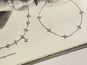 Detailed view of silver clover bracelet with sparkling zircons on a fashion magazine