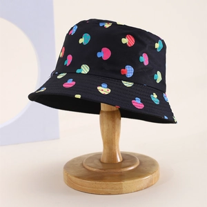 Detail of kids sun hat with colorful mushroom patterns on a wooden display stand