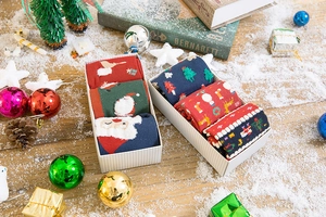 Detail of Christmas gift box with elk and snowflake pattern wool socks in festive packaging