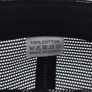 Detailed close-up of 100% cotton label on black mesh breathable baseball cap