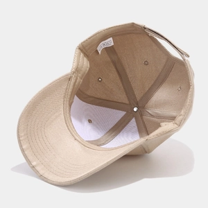 Close-up of beige polyester baseball cap interior featuring 100% polyester wash label