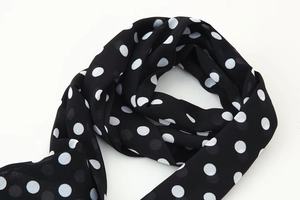 Close-up of black and white polka dot chiffon scarf with lightweight fabric texture