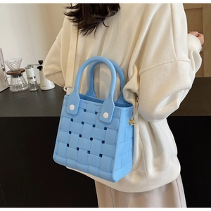 Detail showing blue woven EVA beach bag texture and white rivet handle attachment