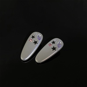 Détail de barrettes argentées en forme d'étoile avec strass colorés et perles